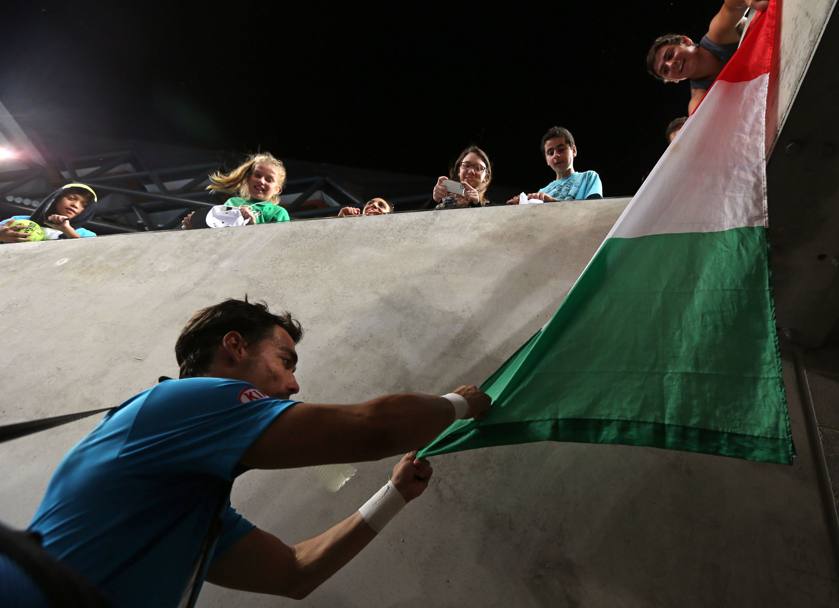 Fabio firma una bandiera tricolore a fine match. LaPresse